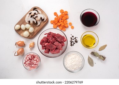 Beef bourguignon. Raw ingredients. Ready to be cooked. Recipe for beef stew, traditional to Burgundy cuisine, cooked in red wine, with a garnish of mushrooms, small onions and bacon. French cuisine.  - Shutterstock ID 2206279769