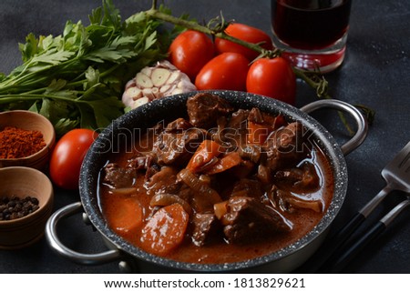 Beef Bourguignon . Stew with red wine ,carrots, onions, garlic, a bouquet garni, and garnished with pearl onions, mushrooms and bacon. French cuisine- regional recipe from Burgundy