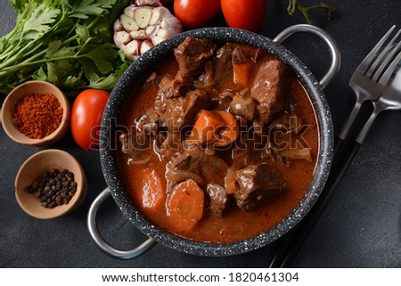 Beef Bourguignon . Stew with red wine ,carrots, onions, garlic, a bouquet garni, and garnished with pearl onions, mushrooms and bacon. French cuisine- regional recipe from Burgundy