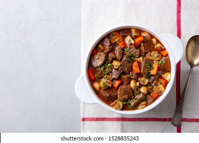 Beef bourguignon stew with vegetables. Grey background. Copy space. Top view.