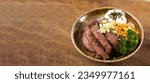 Beef Bowl. bowl of white rice topped with slices of grill beef. Japanese food on restaurant table. Isolate on wood background