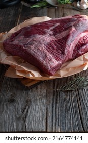 Beef Brisket Raw And Uncooked On Butcher Paper. Served Isolated On Wooden Table Background With Copy Space