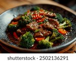 Beef and broccoli stir-fry served in a bowl, captured from an angle view. Professional food photography showcasing a vibrant dish with garnishes.