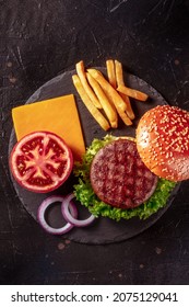 Beef Burger Ingredients, Shot From Above On A Dark Background. Hamburger Beef Patty Steak With Potato And Vegetables