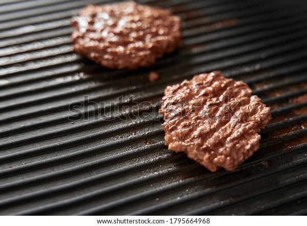 beef burger patties on griddle pan cooking. copy\
space for design mockup