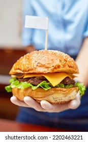 Beef Burgers With Cheddar Cheese Served By Restaurant Waiter Wearing White Gloves For Cleanliness And Safety. Grilled Beef Sliced And Lettuce Top With Cheddar Cheese And Burger Bun With Sesame Seed.