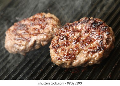 Beef Burgers Cooking On Griddle Plate