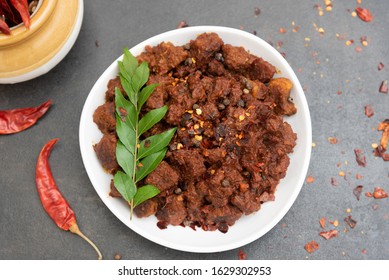 Beef fry curry or mutton fry Kerala India special hot spicy traditional Christian feast dish, dark background. Buffalo roast, meat pepper fry. Top view South Indian non veg food side dish Rice, Appam.