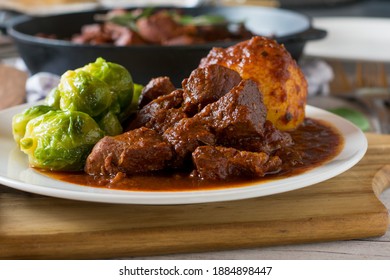 Beef Goulash with brussels sprouts and potato dumplings on a plate