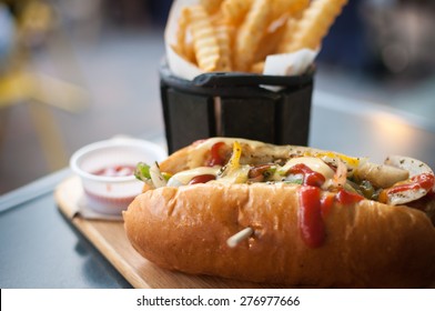Beef Hotdog with french fries on wooden plate in restaurant