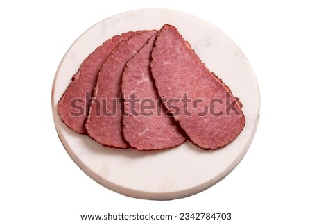 Beef jerky pieces isolated on white background. Sliced pieces of dry meat on a stone floor. close up