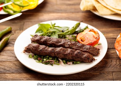 Beef Kebab with salad served in a dish isolated on wooden table background side view of fastfood - Shutterstock ID 2202320115