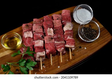 Beef Marinated uncooked Kebabs on Skewers on Wooden tray