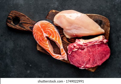  Beef Meat, Salmon Fish Steak And Chicken Breast On A Concrete Background. Raw Food.