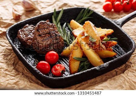 Beef Medallion Grill Roast Country Potato Closeup on Rustic Black Pan Serving for Delicious Recipe. Pork Fillet Cooked on Skillet for Dinner with Rosemary and Salt. Fried Juicy Meat Texture