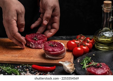 Beef medallions wrapped in bacon with rosemary and spices, Raw beef meat steak Tenderloin fillet on a cutting board. Top view. Copy space. - Powered by Shutterstock