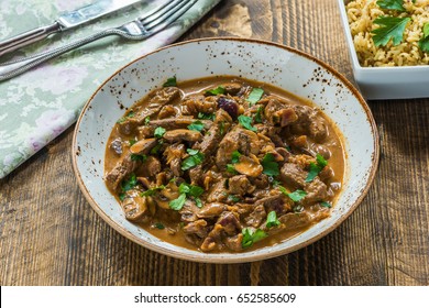 Beef and mushroom Stroganoff with rice on wooden table