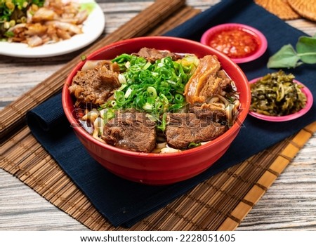 beef noodles with green onion and chili sauce served in a bowl isolated on table top view of taiwanese food