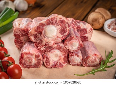 Beef Oxtail Meat On Kitchen Table With Vegetables, Close Up