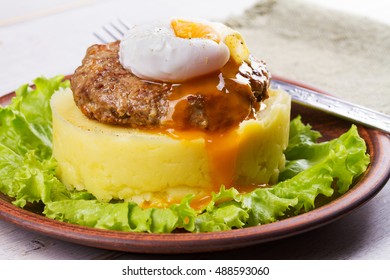 Beef And Pork Sausage Patty With Poached Egg, Smashed Potatoes And Lettuce