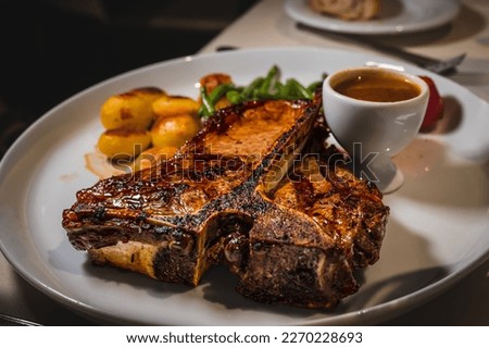 Beef with potatoes. Piece of t-bone steak in the plate with sauce. Delicious and tasty. Stock foto © 