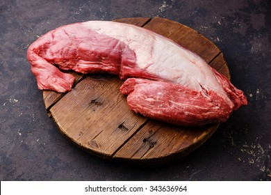 Beef raw fillet tenderloin on cutting board on dark background