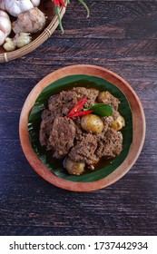 beef rendang padang,spicy meat dish originated from indonesia,famous dish for ied fitr,wooden background,bird eye level