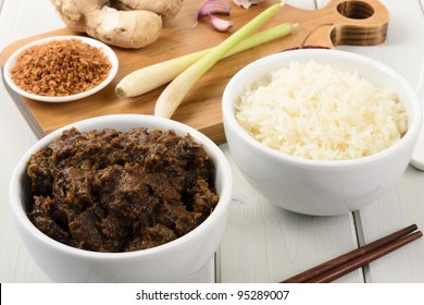Beef Rendang & Sticky Rice - Malaysian/Indonesian spicy dry beef stew served sticky rice. Main dish ingredients on the chopping board (roasted desiccated coconut, ginger and garlic, lemon grass).