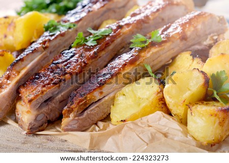 Beef ribs in bbq sauce and baked potatoes,selective focus