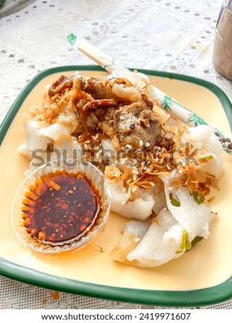 A beef rice noodle roll with chili oil, also known as a steamed rice roll and cheung fun. Ci Cong Fan. Eating steamed chinese dumpling dim sum. Authentic typical chinese food.