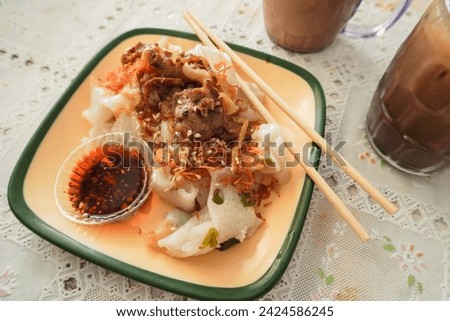 A beef rice noodle roll with chili oil, also known as a steamed rice roll and cheung fun. Ci Cong Fan. Eating steamed chinese dumpling dim sum. Authentic typical chinese food.