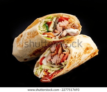 Beef shawarma on a dark background. Shawarma with beef in pita bread. Photo for the menu
