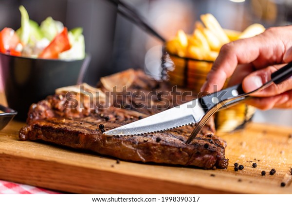 Beef steak\
cut with knife in an american\
restaurant