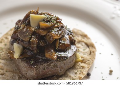 Beef Steak Fillet Covered with Mushroom Sauce on Toasted Baguette Bread with Melting Butter and Herbs