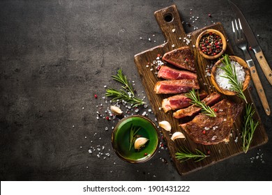 Beef steak. Grilled meat at wooden cutting board. Top view image with copy space.