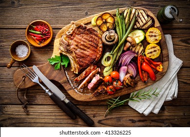 Beef steak with grilled vegetables and seasoning on serving board block - Powered by Shutterstock