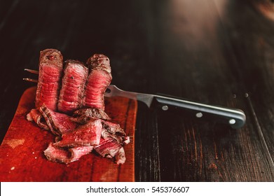 beef steak on a fork on a dark wooden background