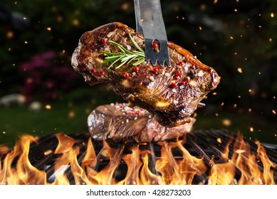 Beef Steak On Grill In Fire With Black Background