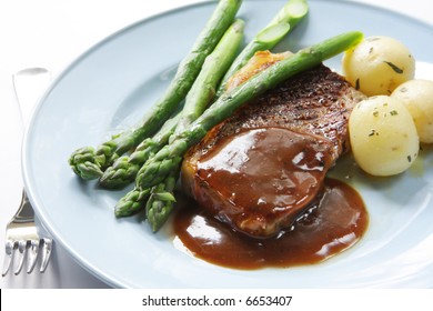 Beef Steak With Peppercorn Sauce, Baby Potatoes And Asparagus.