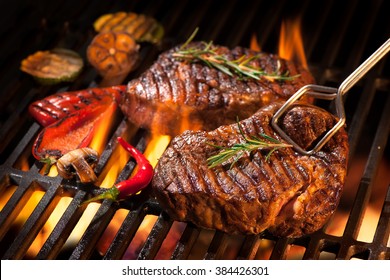 Beef steaks on the grill with flames - Shutterstock ID 384426301