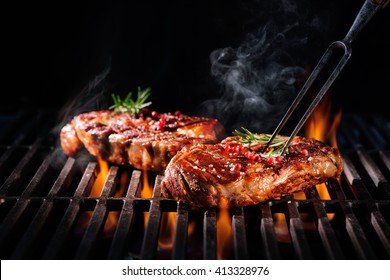 Beef steaks on the grill with flames - Shutterstock ID 413328976