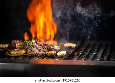 Beef steaks pieces of meat on the grill with flames. American cuisine. The concept cooking meat. Food recipe background. Close up. place for text. - Shutterstock ID 1915981210