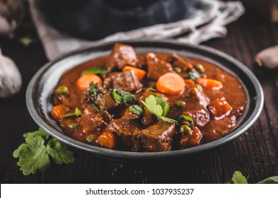 Beef stew with carrots, food photography, lot of herbs inside stew