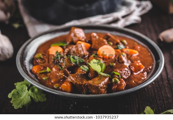 Beef stew with carrots, food photography, lot of\
herbs inside stew