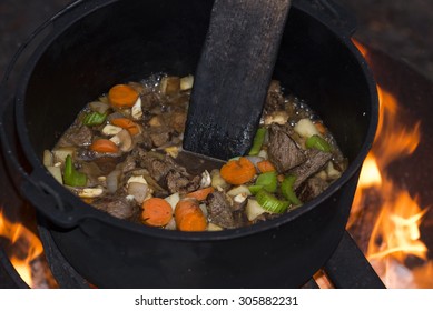 Beef Stew Cooking In A Cast Iron Dutch Oven Over An Open Campfire