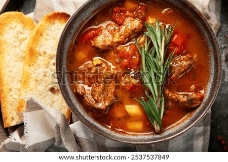 Beef Strips Bourgeon with Carrots and Small Onions in grey Bowl on a wooden background. Top view.