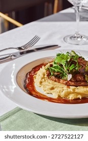 Beef stroganoff with mashed potatoes and herbs in sauce in a plate on the table