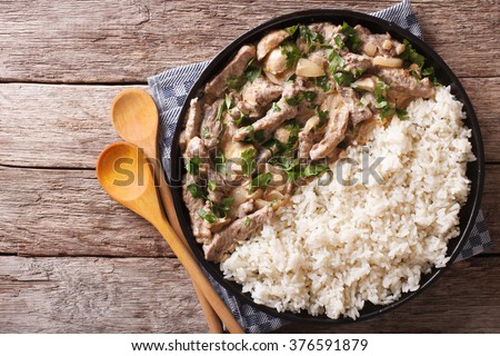beef stroganoff and rice close-up on a plate on the table. horizontal view from above
