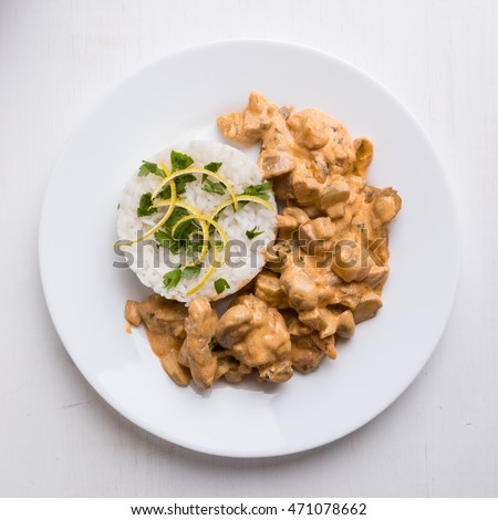 beef stroganoff with rice on white plate