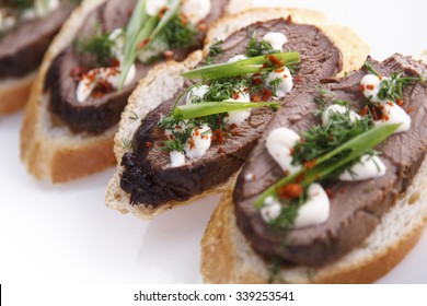Beef Tenderloin Crostini With Green On A Plate